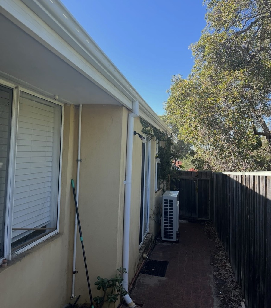 After: The same wall with new white gutters and downpipes